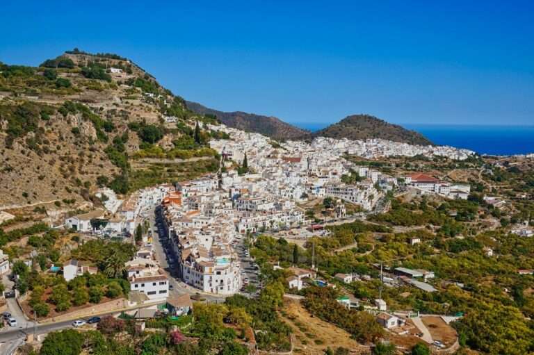 The white village of Frigiliana on its hillside with the Mediterranean beyond